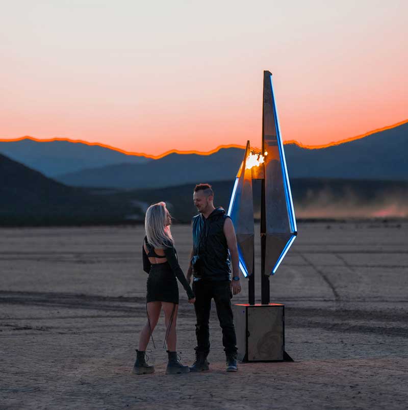 Marie Poliak and Kevin Bracken with their flaming light sculpture, “Split Crystal,” from the Future Fire series, made for Insomniac’s Forever Midnight NYE 2024 event. Photo by Mareks Petersons